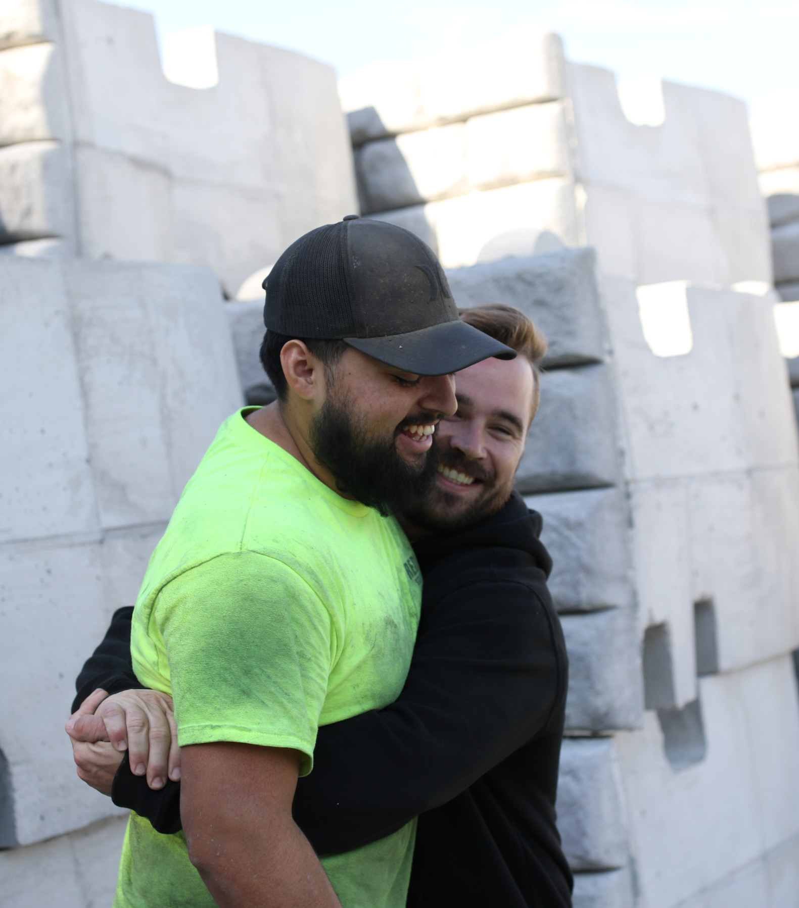 Two construction workers hugging